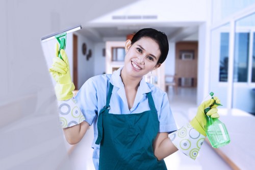 Professional cleaners maintaining desks and shared office spaces in KT2